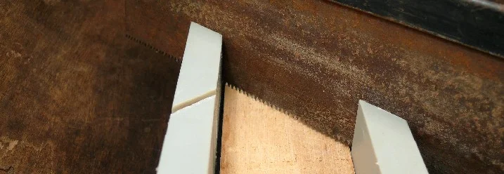 Holz wird mit Handsäge geschnitten.